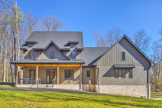 modern farmhouse with a front yard and covered porch