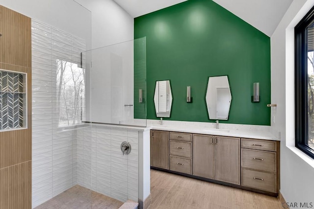 bathroom featuring vanity, a wealth of natural light, and vaulted ceiling