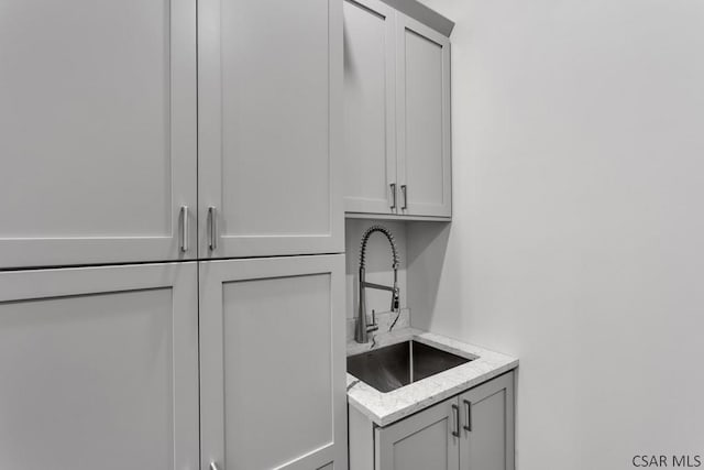 interior space featuring light stone counters and sink