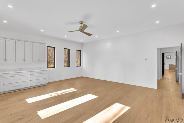 interior space with ceiling fan and light hardwood / wood-style flooring