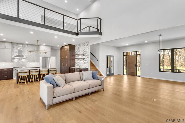 living room featuring a towering ceiling and light hardwood / wood-style flooring