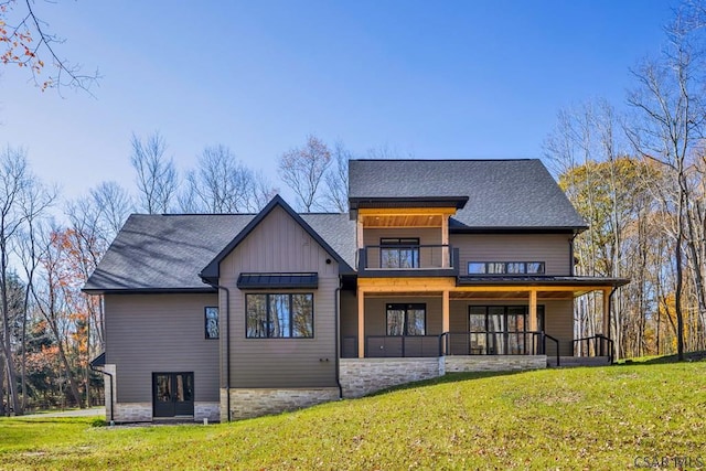 rear view of house with a yard and a balcony