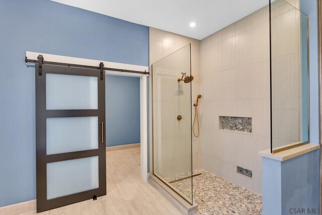 bathroom with wood-type flooring and tiled shower