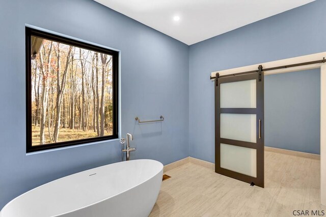 bathroom with a wealth of natural light and a bathtub