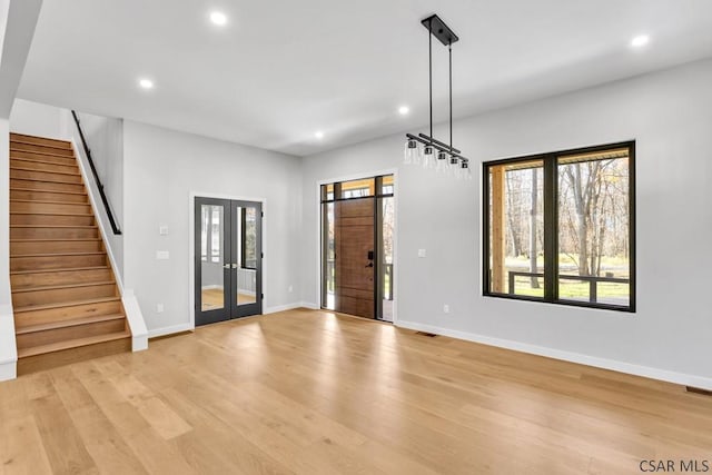 foyer entrance featuring french doors and light hardwood / wood-style floors