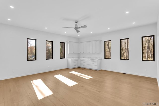 unfurnished bedroom with ceiling fan and light hardwood / wood-style flooring