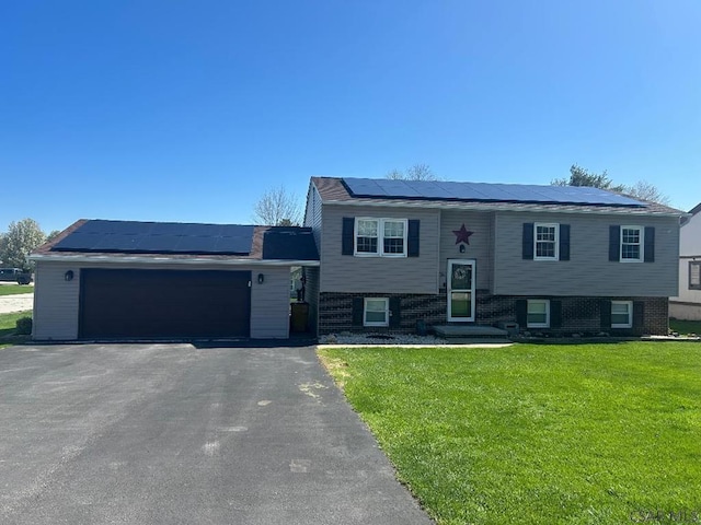 1501 Maplehurst Dr, Somerset, PA 15501 - view of front of property with roof mounted solar panels, a front lawn, asphalt driveway, brick siding, and an attached garage