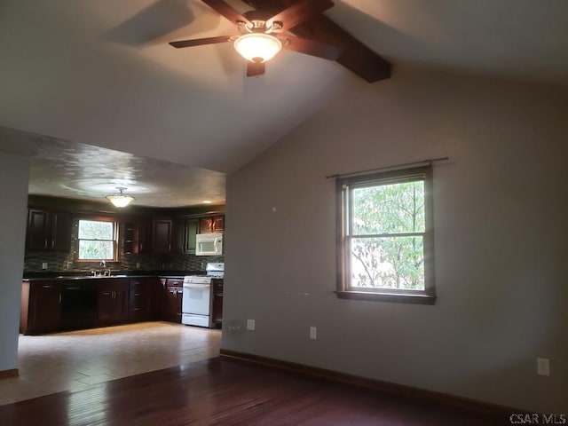 kitchen featuring dark brown cabinetry, vaulted ceiling with beams, hardwood / wood-style flooring, white appliances, and backsplash