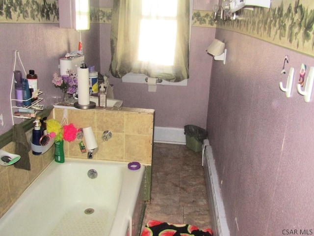 bathroom featuring a bath and baseboards