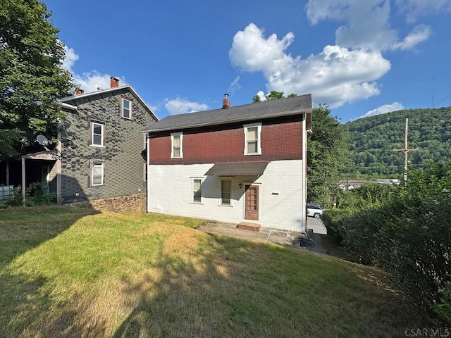 603 Woodvale Ave, Johnstown, PA 15901 - back of property with brick siding, a yard, and a chimney