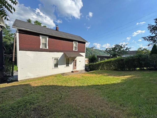 603 Woodvale Ave, Johnstown, PA 15901 - back of property featuring brick siding, a lawn, and a chimney