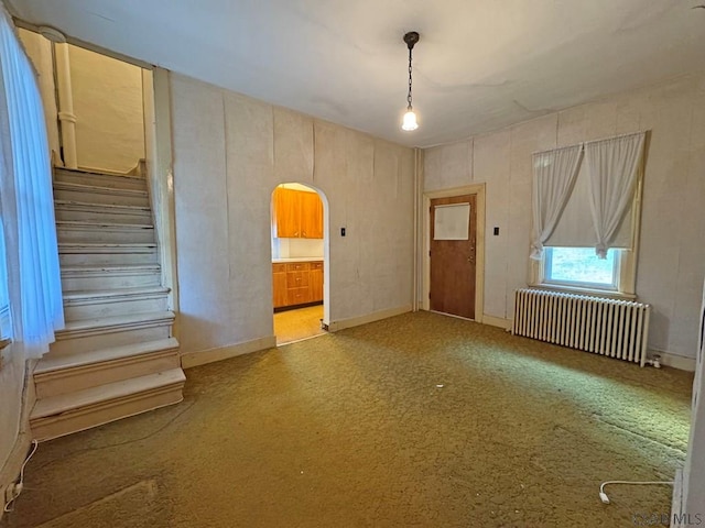 603 Woodvale Ave, Johnstown, PA 15901 - carpeted empty room with radiator, arched walkways, and stairs