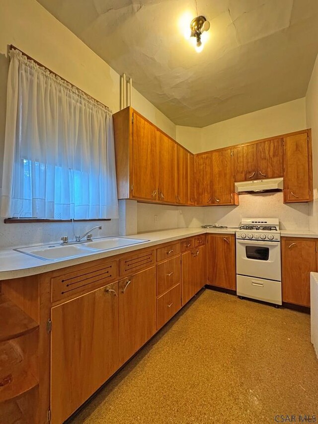 603 Woodvale Ave, Johnstown, PA 15901 - kitchen featuring white range with gas cooktop, under cabinet range hood, brown cabinets, light countertops, and decorative backsplash