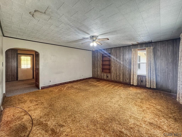 751 Pike Rd, Johnstown, PA 15909 - carpeted spare room with arched walkways, a ceiling fan, and wood walls