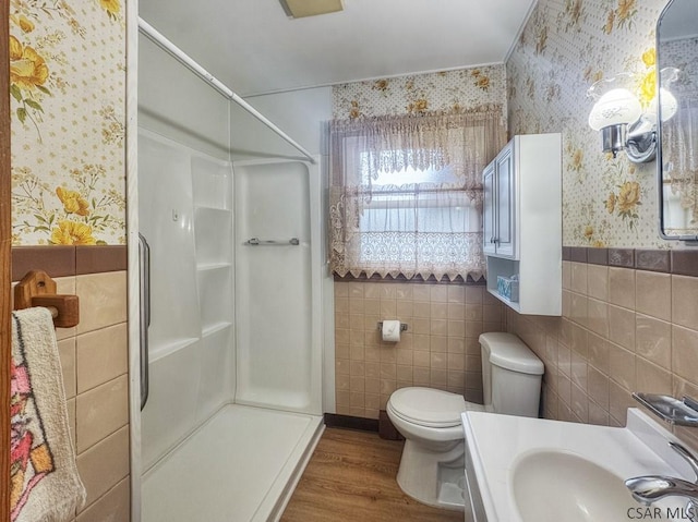 751 Pike Rd, Johnstown, PA 15909 - bathroom with wallpapered walls, a stall shower, wood finished floors, wainscoting, and tile walls
