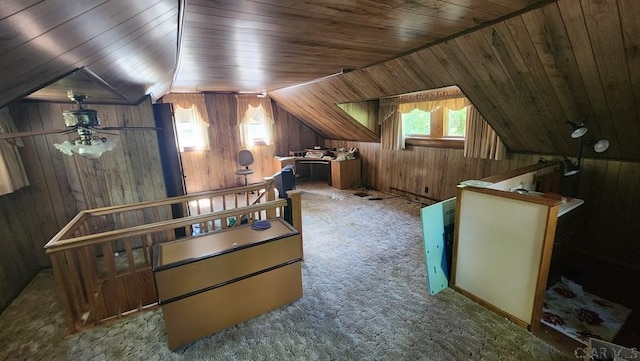 bonus room featuring vaulted ceiling, carpet flooring, a wealth of natural light, and wooden walls