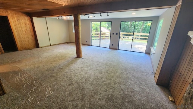 interior space with beamed ceiling, rail lighting, wood ceiling, and wooden walls