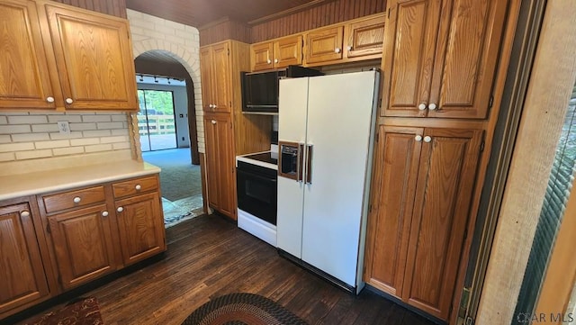 kitchen with ornamental molding, white refrigerator with ice dispenser, electric range, and dark hardwood / wood-style flooring