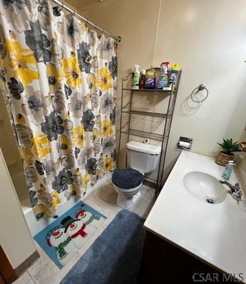 full bathroom featuring shower / tub combo with curtain, vanity, tile patterned floors, and toilet