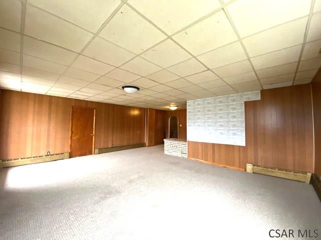 basement featuring a drop ceiling and baseboard heating