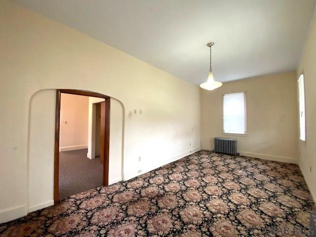 carpeted empty room featuring radiator