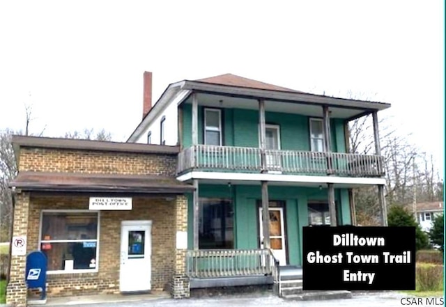 view of front of property featuring a balcony and covered porch