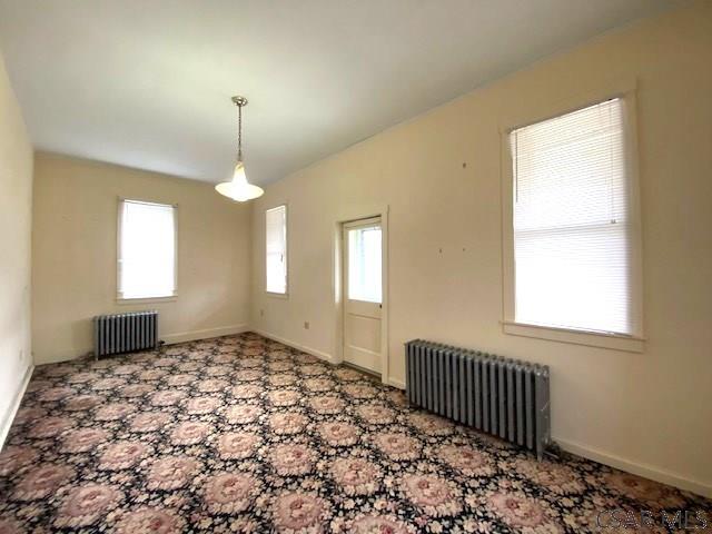 unfurnished room featuring radiator heating unit