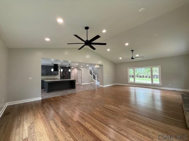 2200 Dundee Ln, Johnstown, PA 15905 - unfurnished living room with a ceiling fan, stairway, wood finished floors, baseboards, and lofted ceiling