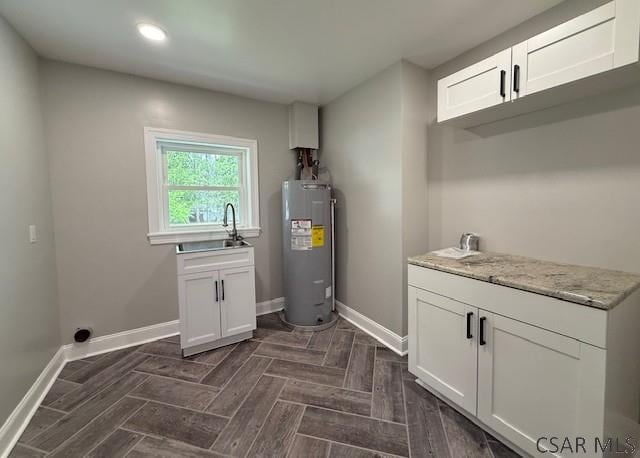 2200 Dundee Ln, Johnstown, PA 15905 - laundry area featuring electric water heater, a sink, baseboards, and recessed lighting