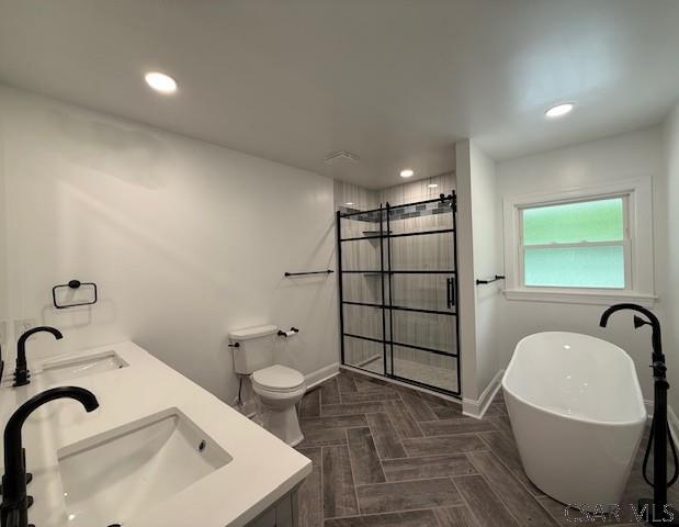 2200 Dundee Ln, Johnstown, PA 15905 - full bathroom featuring a shower stall, baseboards, a freestanding tub, double vanity, and toilet