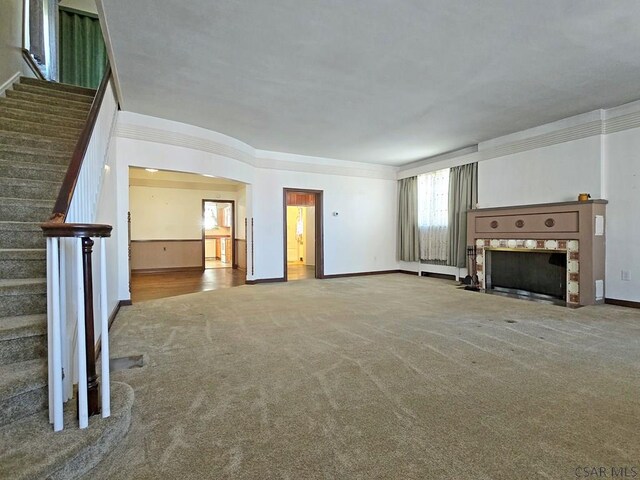 17 Grant St, Salisbury, PA 15558 - unfurnished living room with stairway, carpet floors, ornamental molding, plenty of natural light, and a fireplace with flush hearth