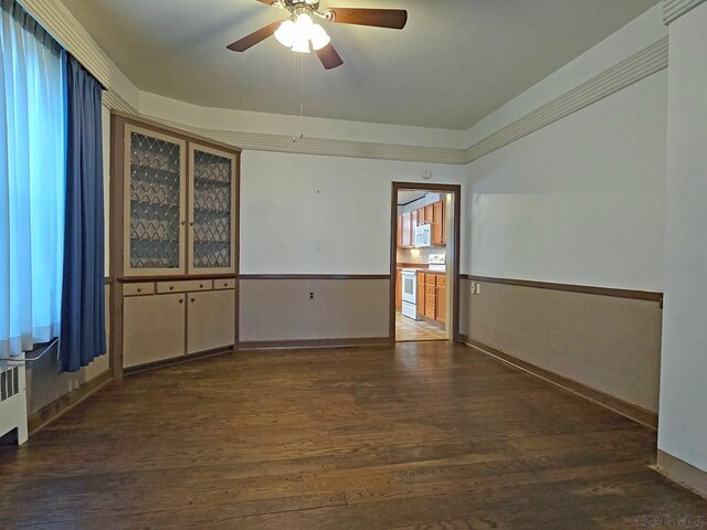 17 Grant St, Salisbury, PA 15558 - empty room featuring dark wood-style flooring, ceiling fan, radiator heating unit, crown molding, and baseboards