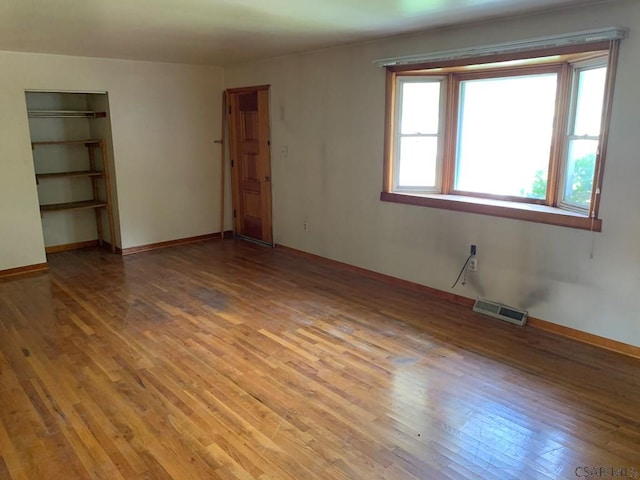 spare room featuring hardwood / wood-style floors and a wealth of natural light