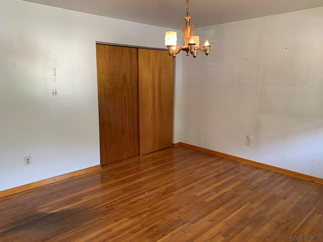 unfurnished room with dark hardwood / wood-style flooring and a chandelier