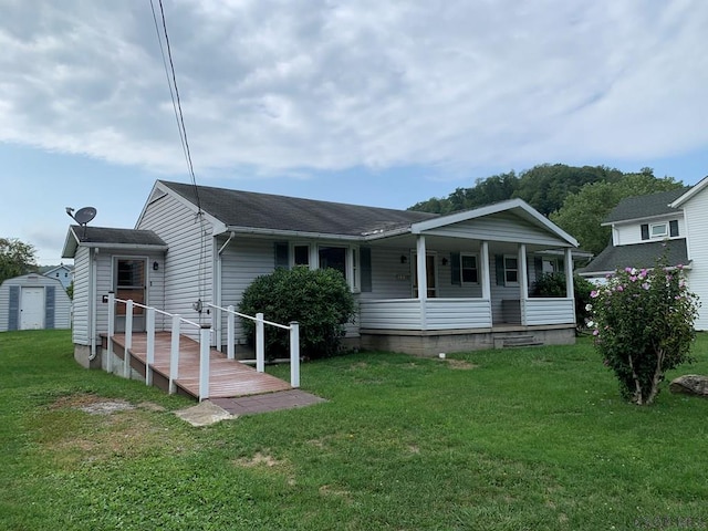 view of front of property featuring a porch, a front yard, and a shed