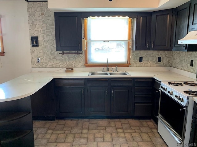 kitchen with a healthy amount of sunlight, sink, backsplash, and white gas range oven