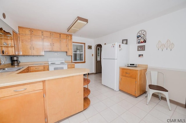 kitchen with light countertops, white appliances, arched walkways, a sink, and open shelves
