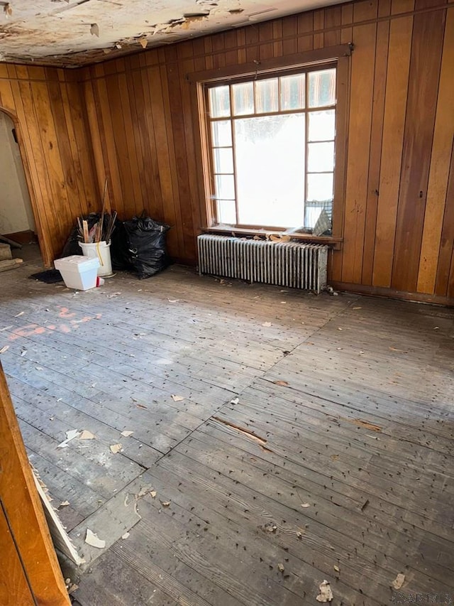 miscellaneous room featuring radiator heating unit and wooden walls