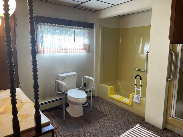 bathroom featuring a baseboard heating unit, a bathing tub, toilet, a shower, and wood finished floors