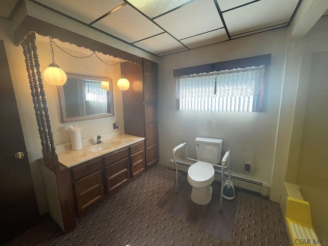 bathroom with baseboard heating, a healthy amount of sunlight, toilet, and vanity