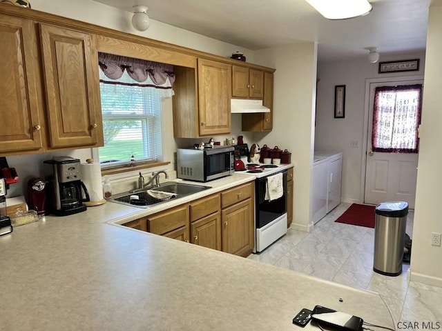 kitchen featuring sink, washing machine and dryer, and range with electric stovetop