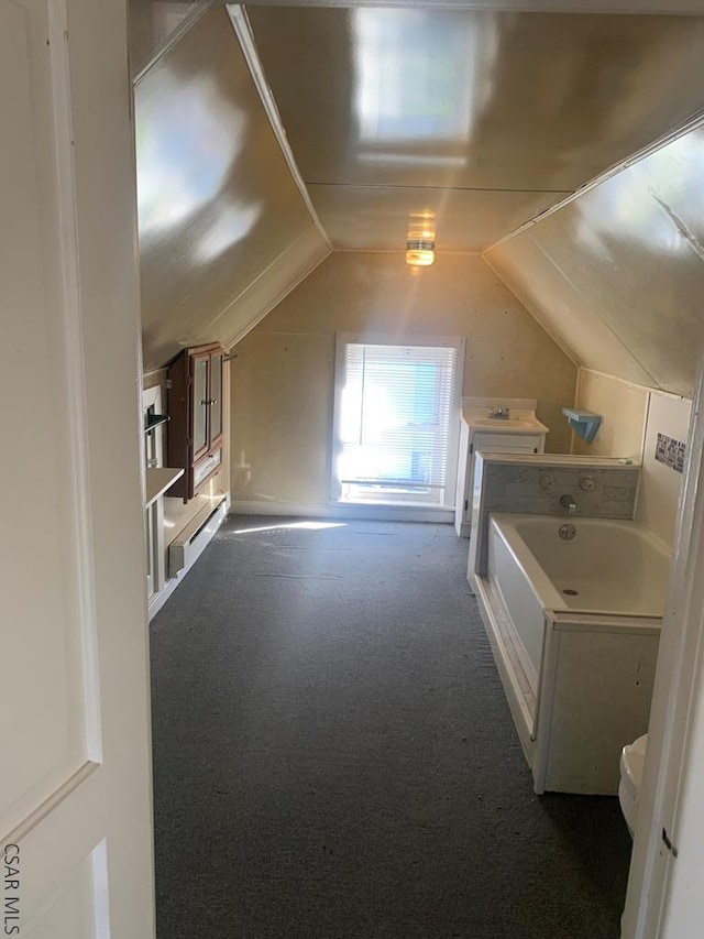 bonus room featuring lofted ceiling and dark carpet