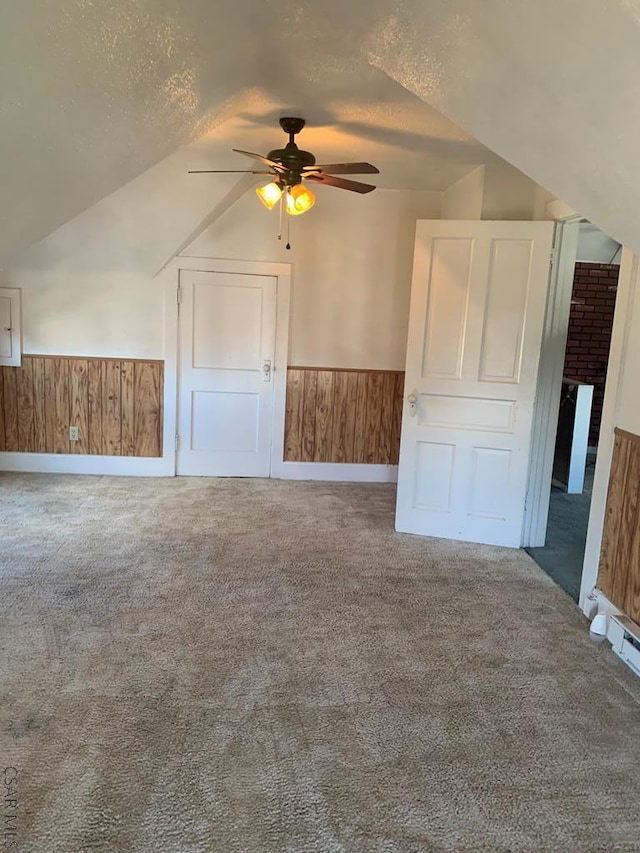 bonus room featuring ceiling fan, vaulted ceiling, a textured ceiling, and carpet flooring