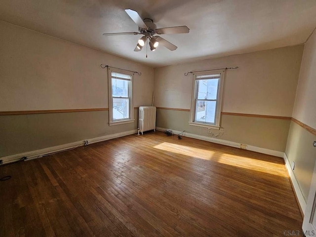 unfurnished room featuring radiator, hardwood / wood-style floors, and ceiling fan