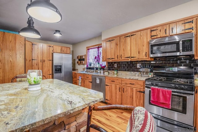 4627 Water Level Rd, Rockwood, PA 15557 - kitchen featuring stainless steel appliances, tasteful backsplash, brown cabinets, light stone countertops, and wood finished floors