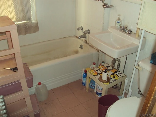 bathroom with tile patterned floors, toilet, sink, and a tub