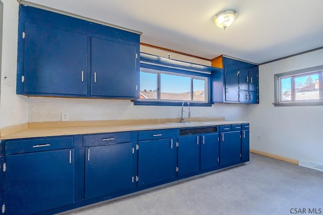 kitchen with visible vents, light countertops, blue cabinets, and a sink