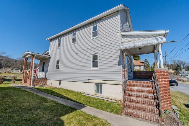 view of home's exterior featuring a yard and covered porch