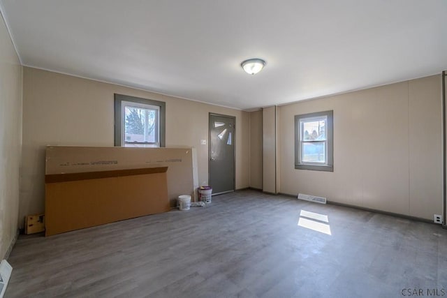 spare room featuring visible vents, a healthy amount of sunlight, and wood finished floors