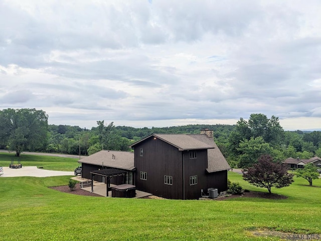 350 American Legion Rd, Latrobe, PA 15650 - view of side of property featuring a patio, a shingled roof, a lawn, and a chimney